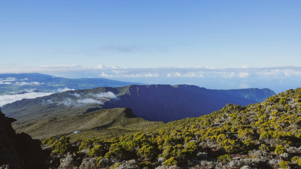 Stunning aerial view of a volcanic landscape on Réunion Island with lush greenery and clear skies.